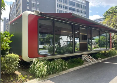 BAUSTADT WA90 space capsule house exterior with panoramic glass wall and red aluminum frame