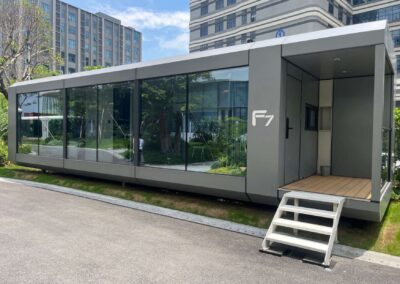 BAUSTADT F70 space capsule modular house exterior front view with glass wall and entrance steps