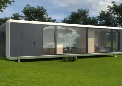 Modern prefabricated container office unit with large windows installed on landscaped lawn.